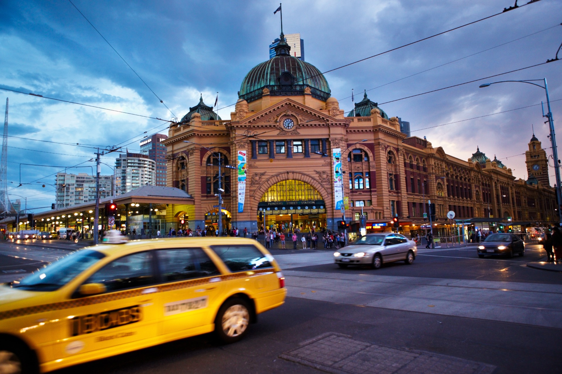 flinders st station with cars in the foreground